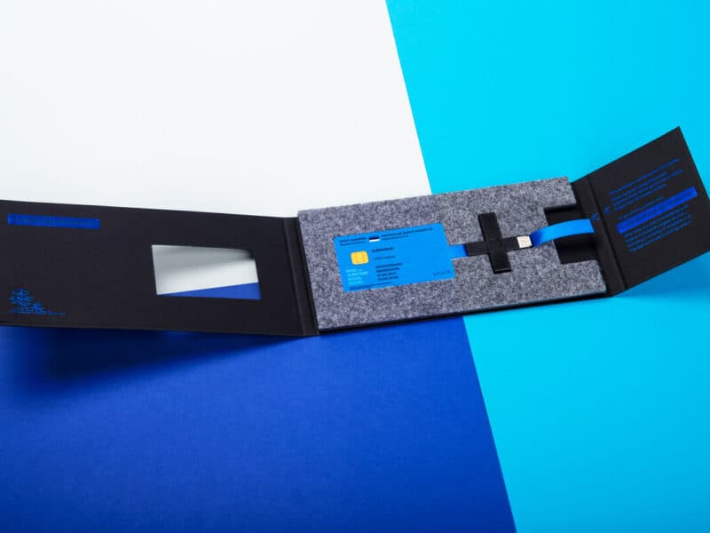 Digital Estonian e-Residency card and secure ID kit on blue background.