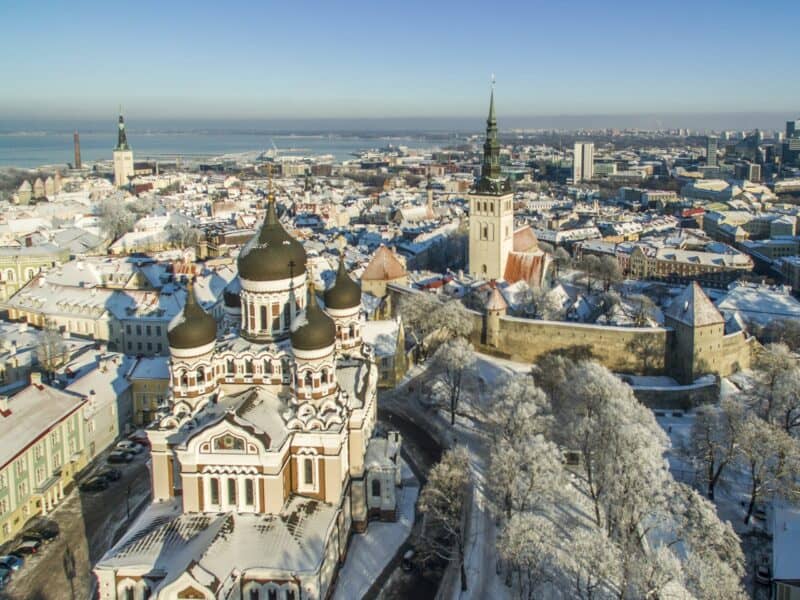 Tallinn city view featuring snow-covered historic churches and architecture in winter.