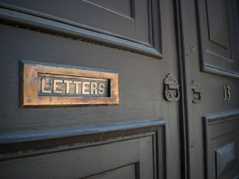 Brass letter slot on a dark office door