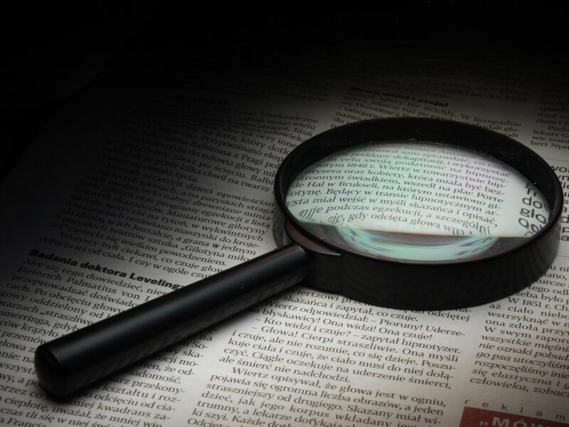 Magnifying glass on a document, verifying the beneficial owner of an Estonian company